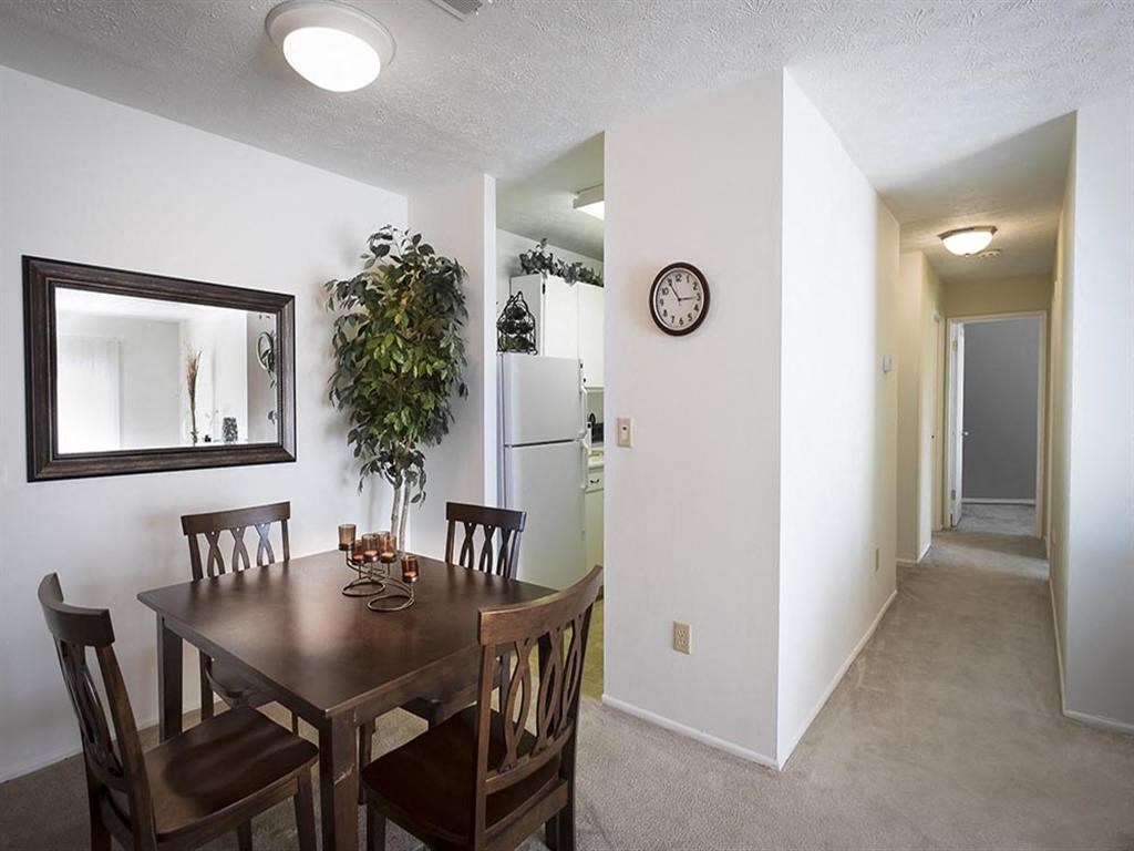 a dining room with a table and a clock on the wall