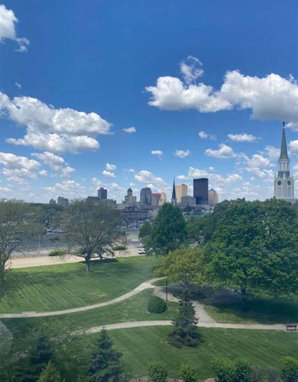 Dayton, OH skyline is visible through a lush green park.