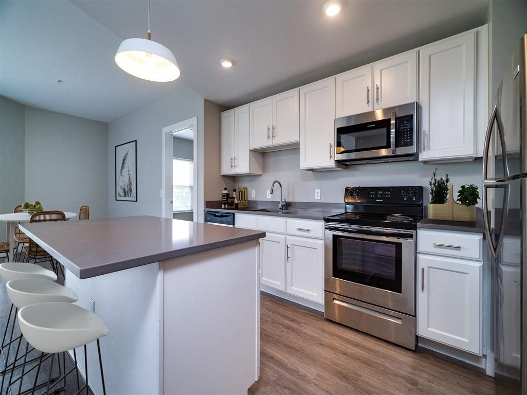 a kitchen with white cabinets and stainless steel appliances