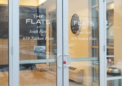 a glass door with a sign for the flats on it