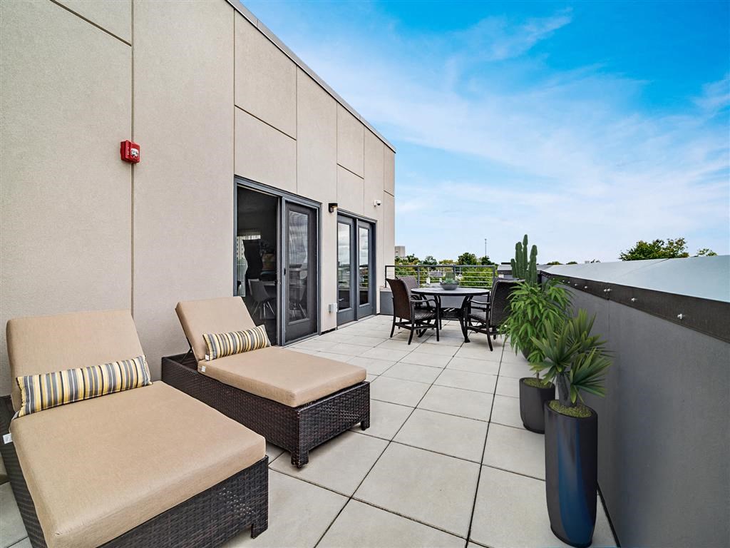 a patio with chairs and a table on a roof