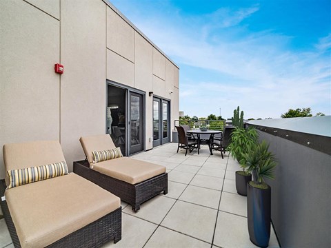 a patio with chairs and a table on a roof
