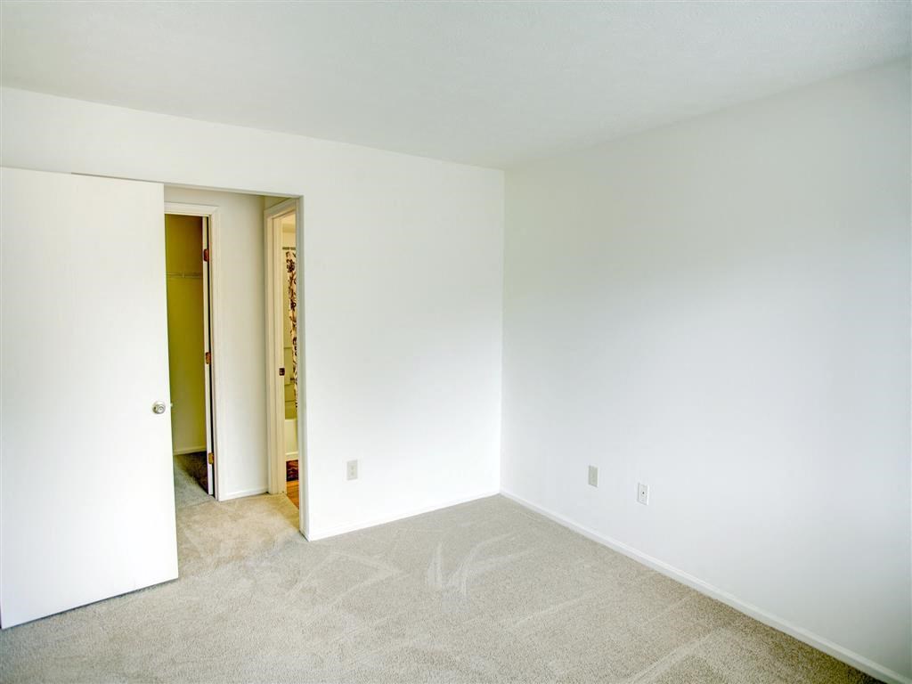 an empty room with white walls and carpet