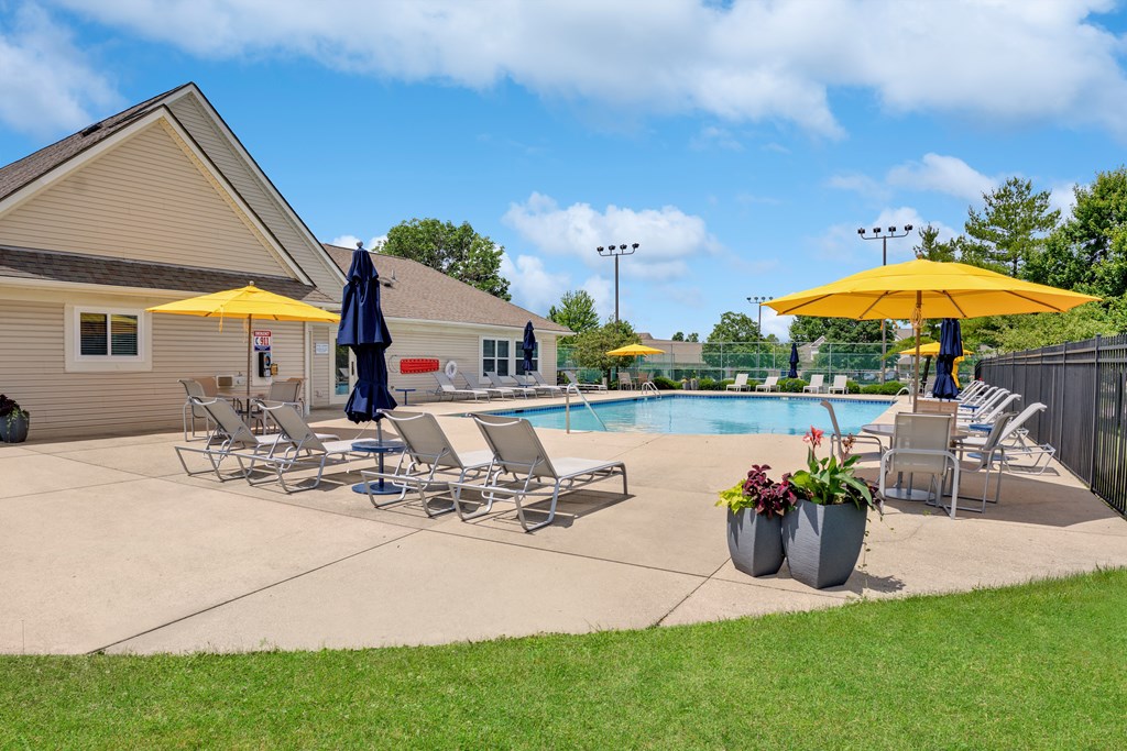 A poolside area with chairs and umbrellas.