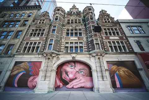A mural of a man's face is painted on the side of a building.