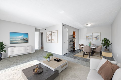 A modern living room with a white sofa, a coffee table, and a painting on the wall.