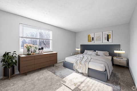 A bedroom with a large bed and a wooden dresser with a plant on it.
