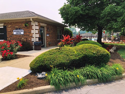 A small building with a sign that says "Information Center" is surrounded by a flower bed.