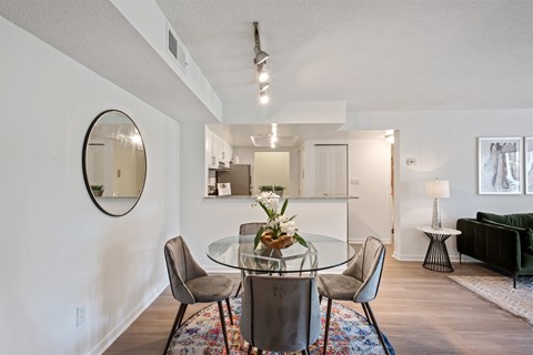A dining room with a glass table and chairs.
