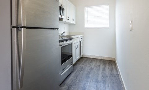 A kitchen with a stainless steel refrigerator and oven.