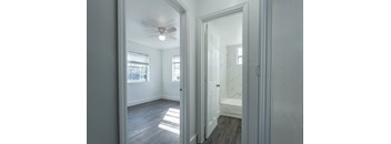 A room with a ceiling fan and a door leading to another room.