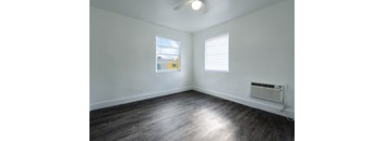 A room with a window and a fan on the ceiling.