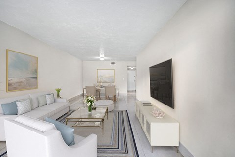 A living room with a white couch and a painting on the wall.