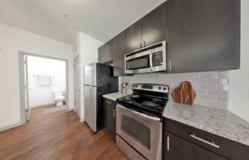 A kitchen with a stove, oven, refrigerator, and microwave.