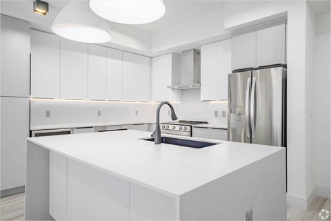 A modern kitchen with white cabinets and appliances.