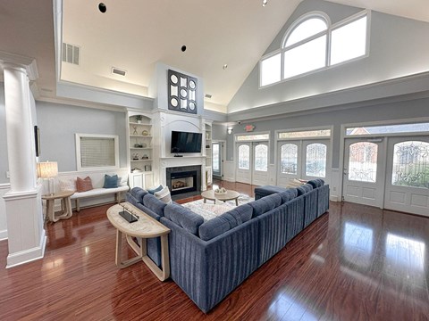 A living room with a blue couch and a fireplace.