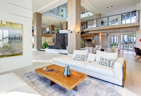 A modern living room with a white couch and a wooden coffee table.