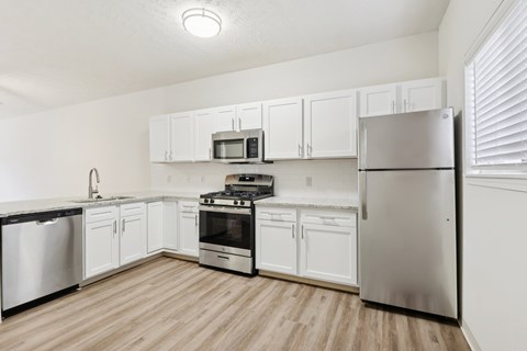 A kitchen with white cabinets and stainless steel appliances.