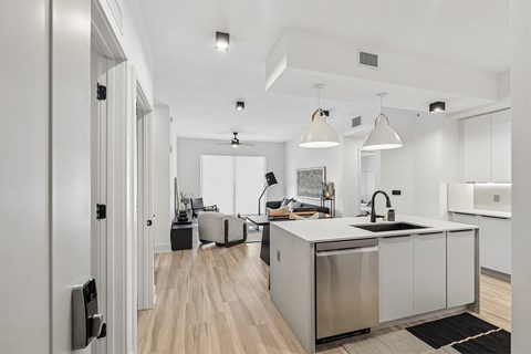 A modern kitchen with a white countertop and stainless steel appliances.