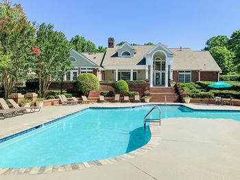 A house with a pool in front of it.