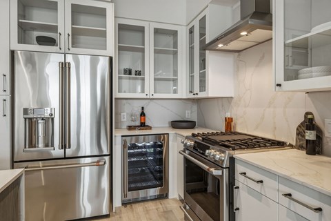 A modern kitchen with a stainless steel refrigerator and oven.