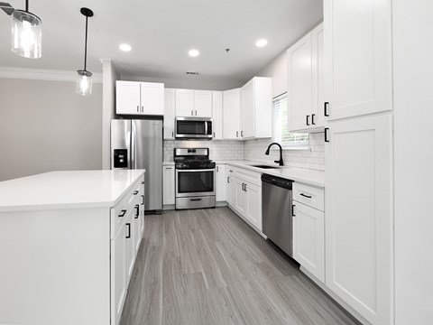A modern kitchen with white cabinets and stainless steel appliances.