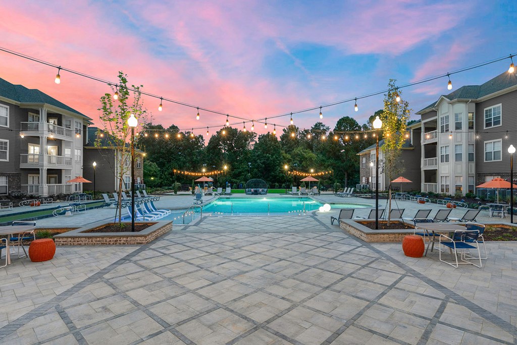 Saltwater pool with outdoor entertaining areas with bistro string lights during sunset