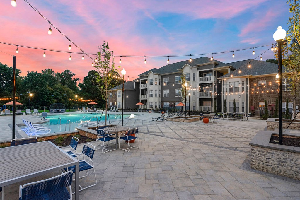 Saltwater pool with outdoor entertaining areas with bistro string lights during sunset