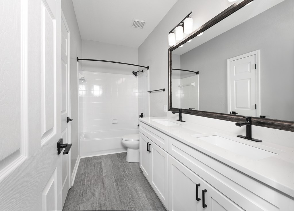 Bathrooms with double vanity sinks, garden soaking tubs and curved shower rods