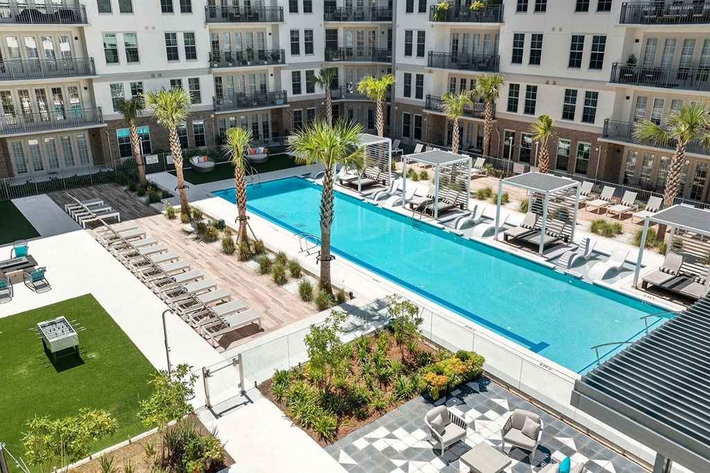 Aerial view of infinity-edge saltwater pool with wet deck lounge, cabanas, lounge chairs and day beds