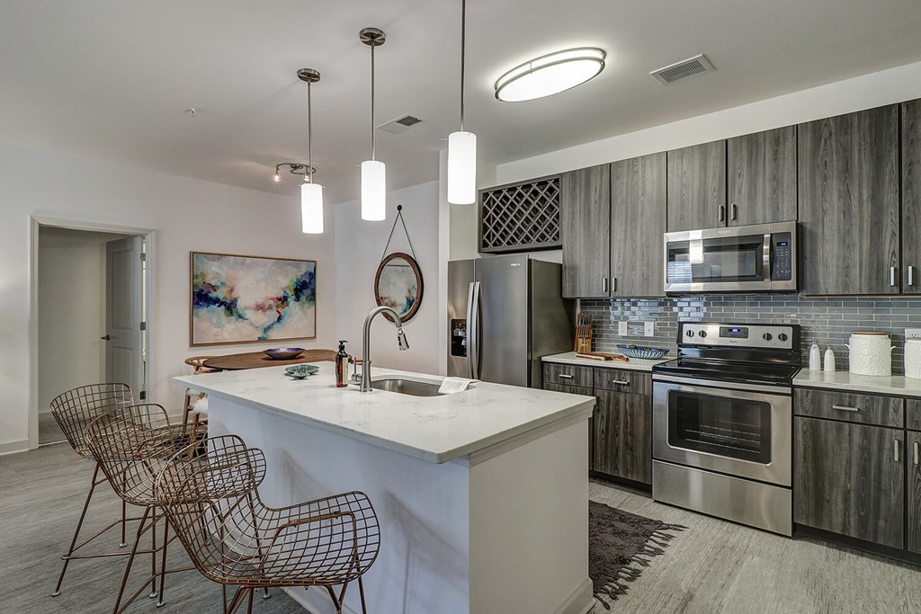 Chef's kitchens feature islands with quartz countertops, undermount sinks and stainless steel appliances