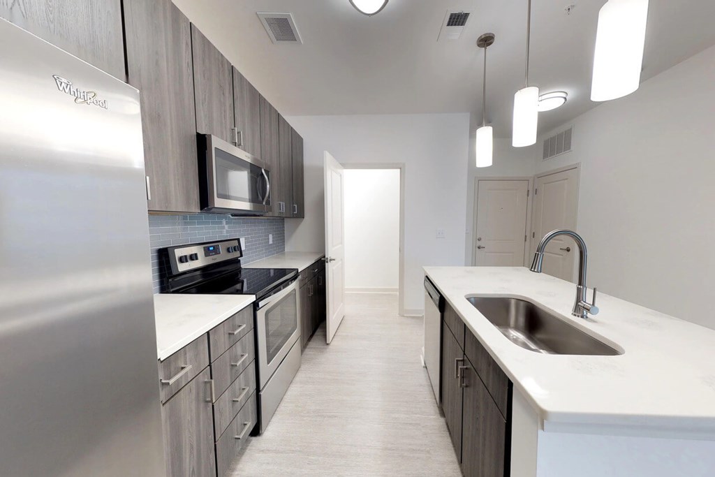 Chef's kitchens feature islands with quartz countertops, undermount sinks, stainless steel appliances