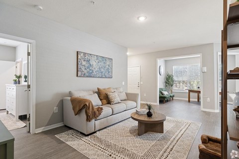 A living room with a couch, a coffee table, and a painting on the wall.