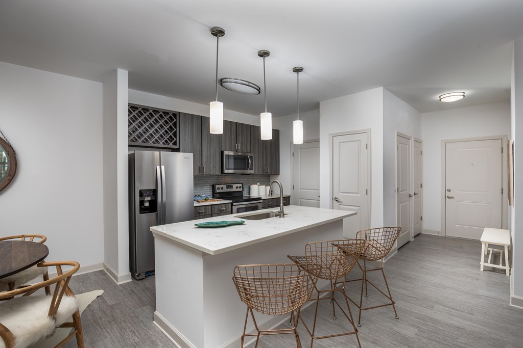 Spacious kitchens with quartz countertops, stainless steel appliances and wine storage above fridge