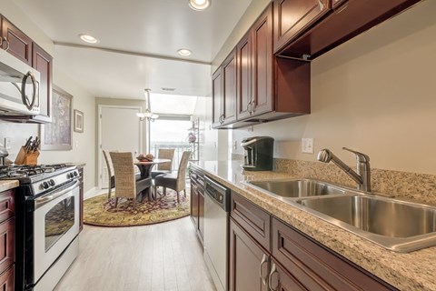 A kitchen with brown cabinets and a stove top oven.