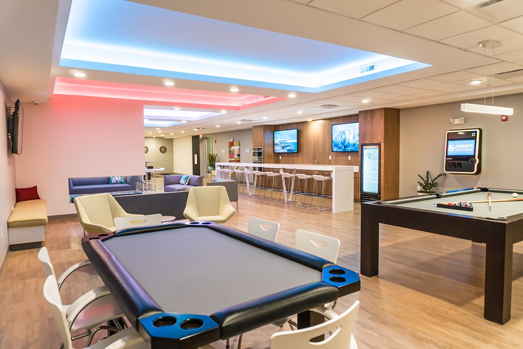 Gaming lounge with poker table, billiards, shuffleboard, darts and fireplace