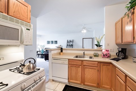 A kitchen with a white stove and wooden cabinets.
