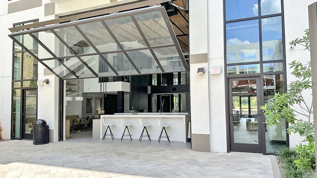 Impressive multi-story clubhouse with glass garage-style doors that open to outside