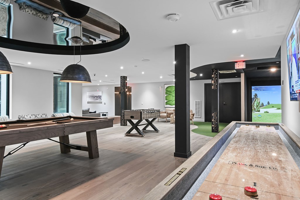 Pool table, shuffleboard, and virtual golf in gaming lounge