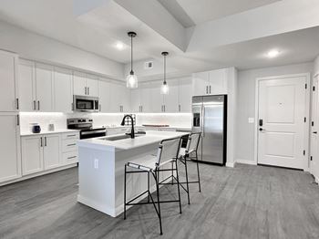 A modern kitchen with a white island and stainless steel appliances.