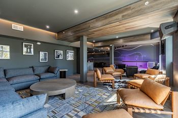 A modern living room with a grey couch and wooden furniture.