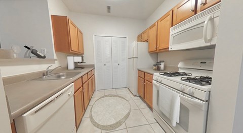 A kitchen with white appliances and wooden cabinets.