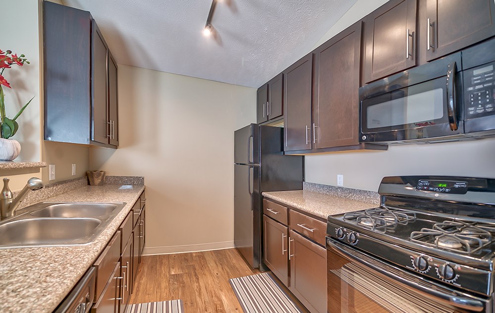 Fully-equipped kitchens with sleek black appliance package and granite countertops