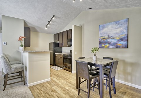 A kitchen with a table and chairs in front of a painting.