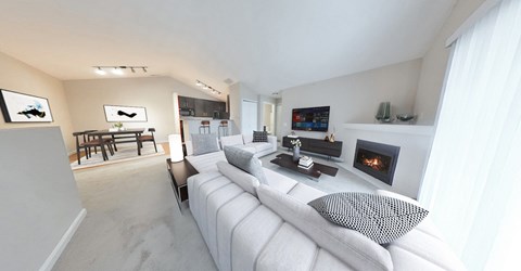 A white couch with a pillow is in the middle of a living room.