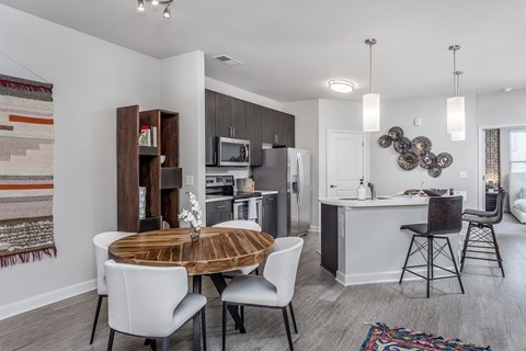 A modern kitchen with a dining table and chairs.