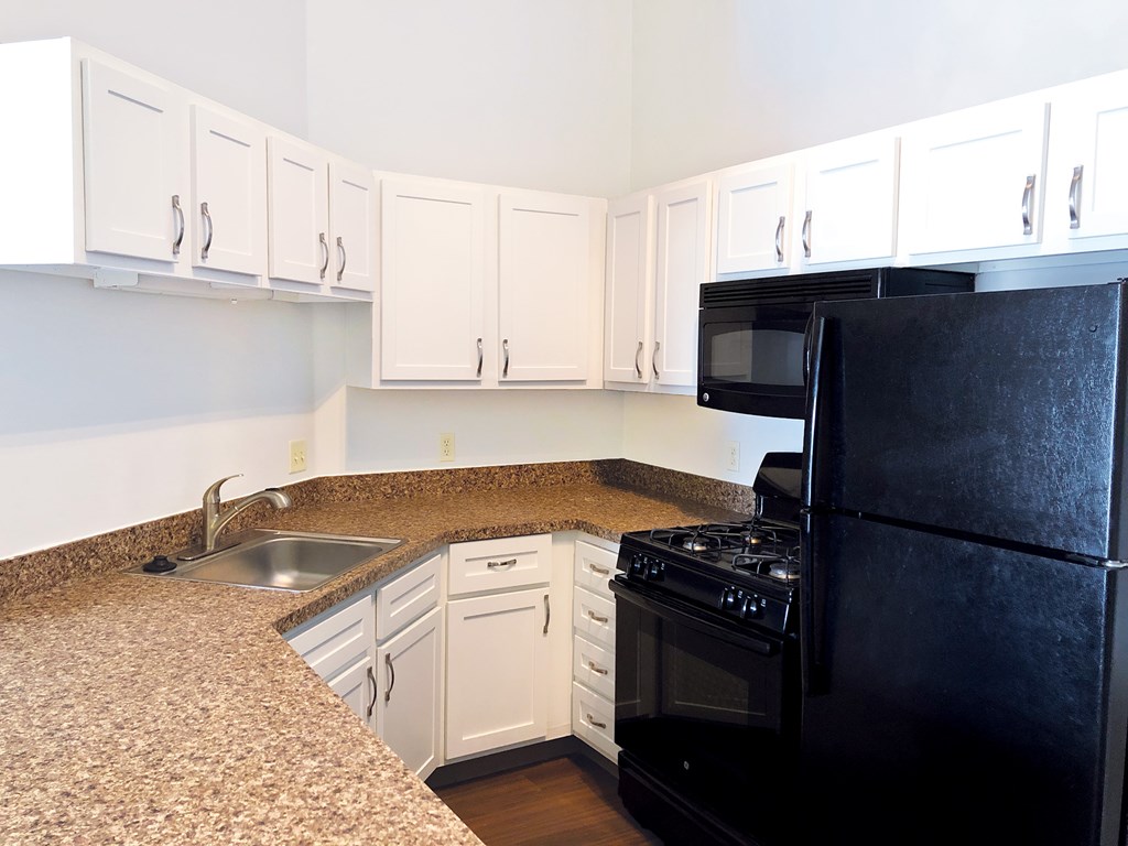 Kitchen with white cabinets and black appliances