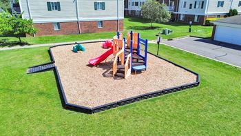 A playground with a red slide and a blue slide.