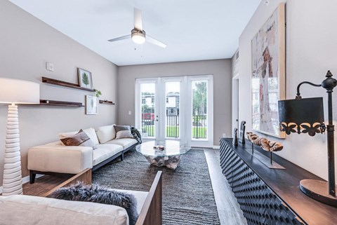 A living room with a white couch, a coffee table, and a large painting on the wall.