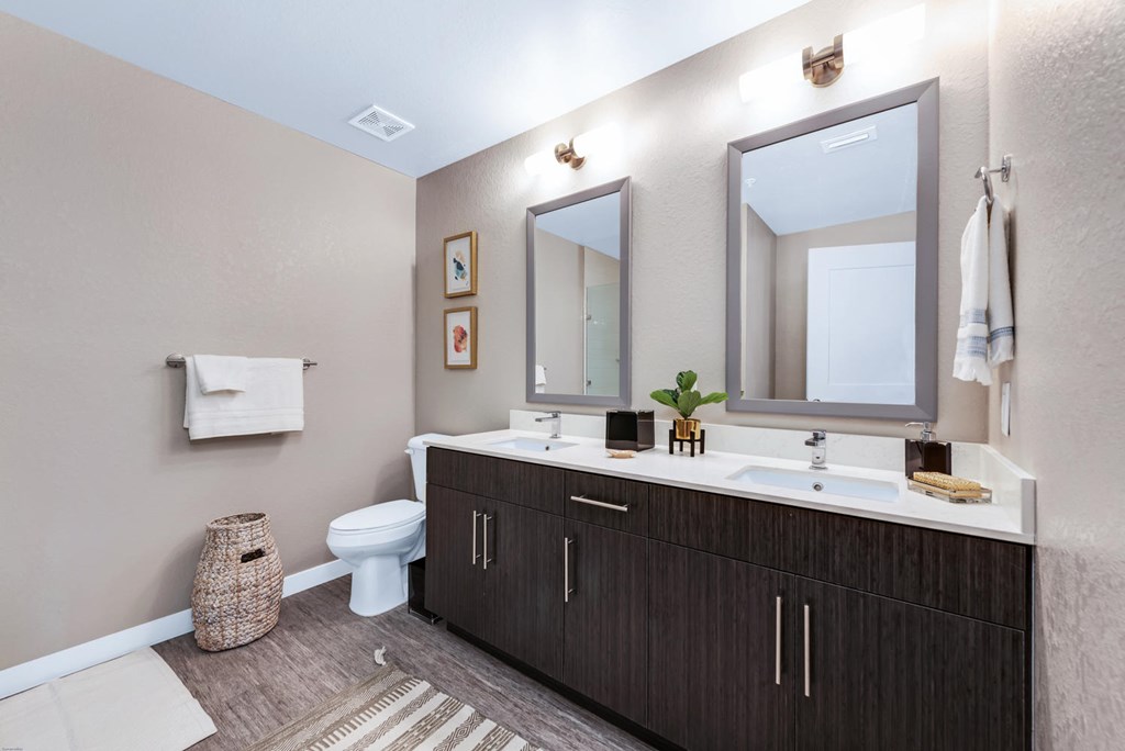 Large bathrooms with dual vanities and framed mirrors